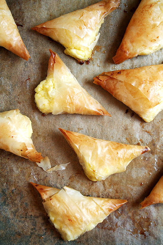 Tiropitas, cheese-and-egg filled fillo triangles, are always a party favorite. What's more, they're not complicated and can be made ahead and stashed in the freezer — perfect to have on hand for entertaining (including Easter Sunday!). // m.simonrockett.com 一个平底锅刚刚烤tiropitas。